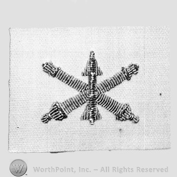 Insignia consisted of embroidered crossed cannon with a missile at the intersection.