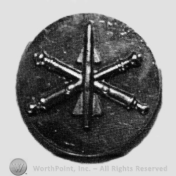 Insignia consisted of crossed cannon with a missile at the intersection; all on a plate.