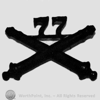 Insignia consisted of crossed cannon and number 77 above.