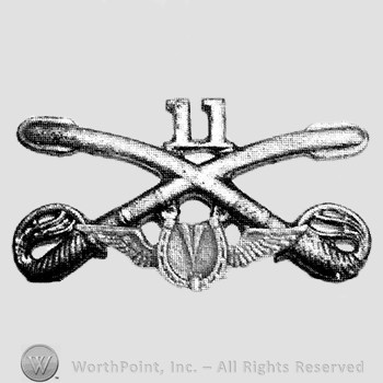 Insignia consisted of crossed sabres and number 11 above and winged horseshoe below.