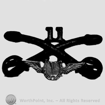 Insignia consisted of crossed sabres and number 11 above and winged horseshoe below.