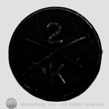 Disc with crossed sabres on and number 2 above and letter K below.