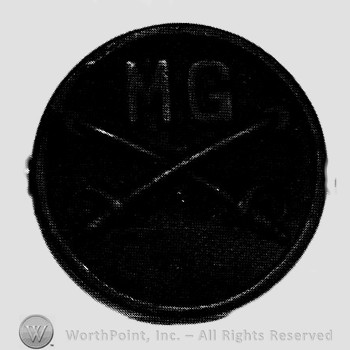 Disc with crossed sabres and letters MG above.