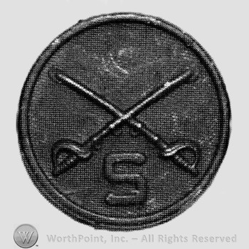 Disc with crossed sabres and letter S below.