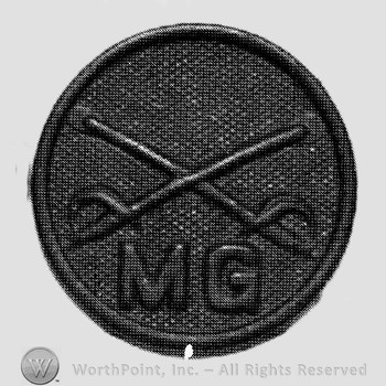 Disc with crossed sabres and letters MG below.
