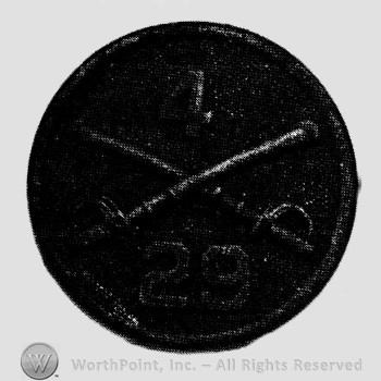 Disc with crossed sabres and number 4 above and number 29 below.