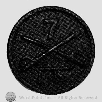 Disc with crossed sabres and number 7 above and a gun below.