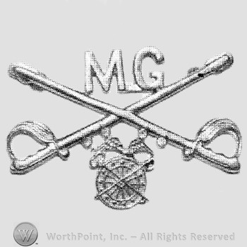 Insignia consisted of crossed sabres and letters MG at the intersection; winged wheel below.