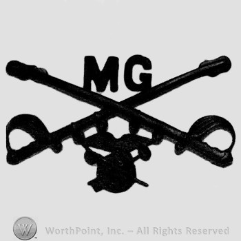 Insignia consisted of crossed sabres and letters MG at the intersection; winged wheel below.