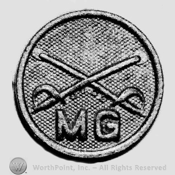 Insignia consisted of collar disc with crossed sabres on and letters  MG below the intersection.