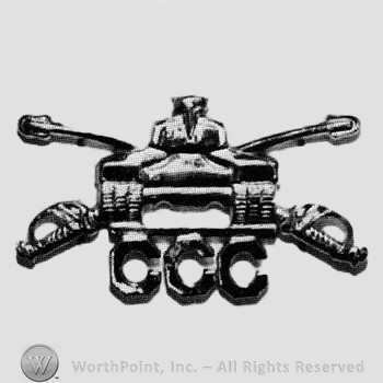 Insignia consisted of crossed sabres, front view of a tank and letters CCC.