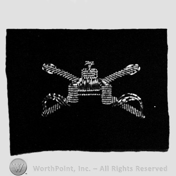 Insignia consisted of crossed sabres, front view of a tank; embroidered.