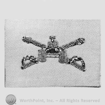 Insignia consisted of crossed sabres, front view of a tank; embroidered.