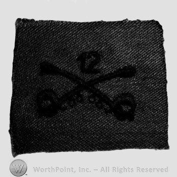 Insignia consisted of crossed sabres and number 12 above.