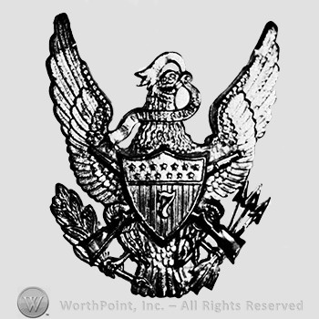 Insignia consisted of eagle gold-plated, with detachable shield and rifles worn with regimental number in silver on the shield; arrows and branch in the claws of the eagle and a ribbon in the beak; number 7 on the shield.