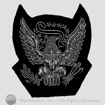 Insignia consisted of eagle with detachable shield and rifles; arrows and branch in the claws of the eagle and a ribbon in the beak; embroidered.