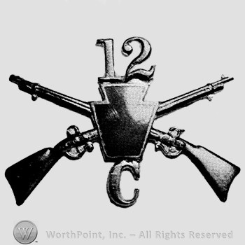Insignia consisted of crossed riffles, shield, number 12 above and letter C below.