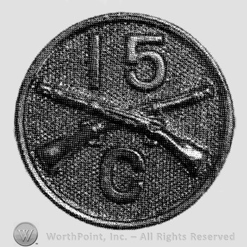 Insignia consisted of disc with crossed rifles on, number 15 above the intersection and letter C below.