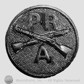 Insignia consisted of disc with crossed rifles on, letters PR above the intersection and letter A below.