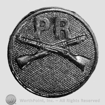 Insignia consisted of disc with crossed rifles on and letters PR above the intersection.