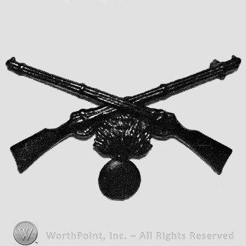 Insignia consisted of crossed rifles and a shell with flame below.