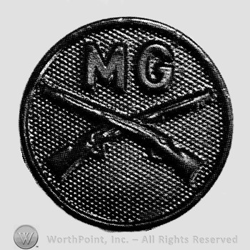 Insignia consisted of disc with crossed rifles on and letters MG above the intersection.