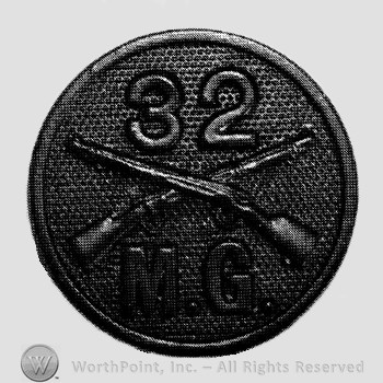 Insignia consisted of disc with crossed rifles on, number 32 above the intersection and letters MG below.