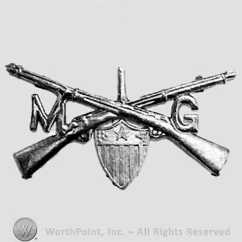 Insignia consisted of crossed rifles, number 1 above the intersection, shield below and letters M and G on the right and on the left.
