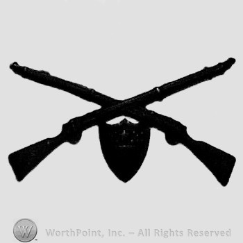Insignia consisted of crossed rifles and a shield below the intersection.