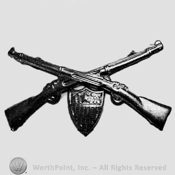 Insignia consisted of crossed rifles and a shield below the intersection.
