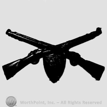 Insignia consisted of crossed rifles and a shield below the intersection.
