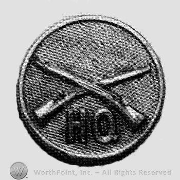 Insignia consisted of crossed rifles and letters HQ below on a disc.