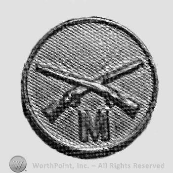 Insignia consisted of crossed rifles and letter M below on a disc.