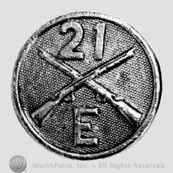 Insignia consisted of crossed rifles, number 21 above the intersection, letter E below; all on a disc.