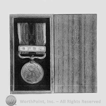 Medal in issue case; ribbon in two colors; flags and flower on the medal.