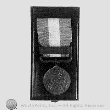 Boxed war medal; crossed flag and a flower on the medal.