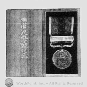 Boxed war medal; crossed flag and a flower on the medal.