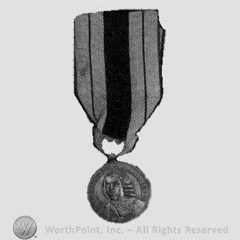 Medal with two colored ribbon and a man's head on the plate.