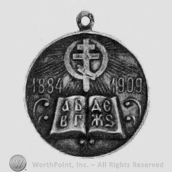 Silver teacher's merit medal has dual profile on obv. & cross, book & dates 1884-1909 on rev.