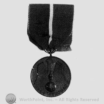 Dark pendant with a bomb; ribbon in two colors.