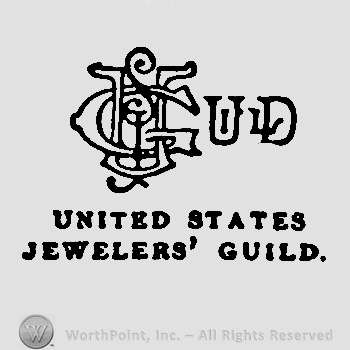 Uppercase outlined letters GJU, entwined, followed by uppercase ULD, United States Jeweles' Guild written below with uppercase letters. 
