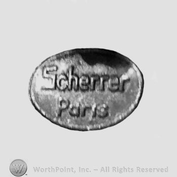 The text ''Scherrer Paris'' in a circle.