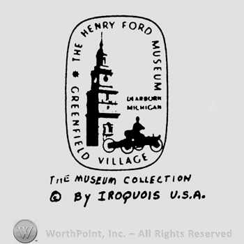 Image of a clocktower and a vintage car inside a rectangle. Under is written By Iroquois U.S.A.