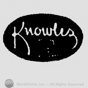White writing on a black oval: Knowles