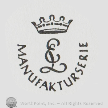 a crown above uppercase handwritten entwined EL, Manufakturserie written below with uppercase letters