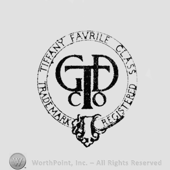Monogram of letters "TGDCO" inside two circles, "Tiffany Favrile Glass" up, "Trade Mark Registered" down between them
