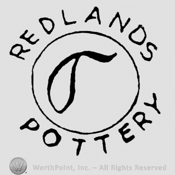 Curved writing above the circle: Redlands, curved writing below the circle: Pottery. Image of a leaf inside the circle