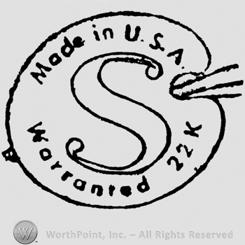 Made in USA written above, Warranted 22 k written below. In the center is a stylish initial S. All inside a painter's pallet form