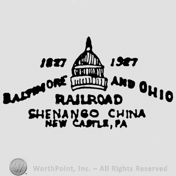 A dome with 1827 written above Baltimore on it's left and 1927 written above  and Ohio on it's right all above Railroad written above Shenango China written above New Castle Pa