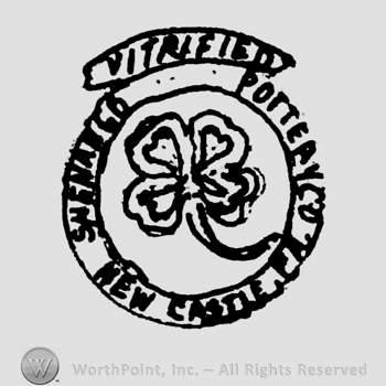 Vitrified written on a ribbon above Shenango Pottery Co New Castle Pa written in circle, inside of a circle shape frame with a clover in the middle